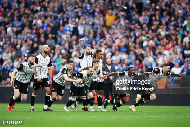 Players of Notts County celebrate after Cedwyn Scott of Notts County scores the team's fifth penalty of the penalty shootout to secure promotion to...