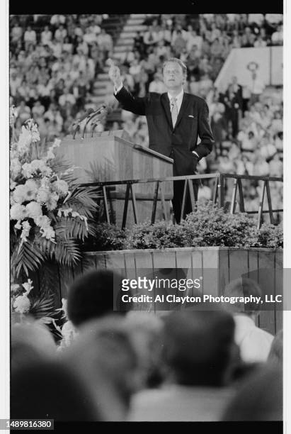 Billy Graham preaching at the seventh stop of a ten day Graham Crusade, standing on a temporary stage in the end zone of Neyland Stadium on the...