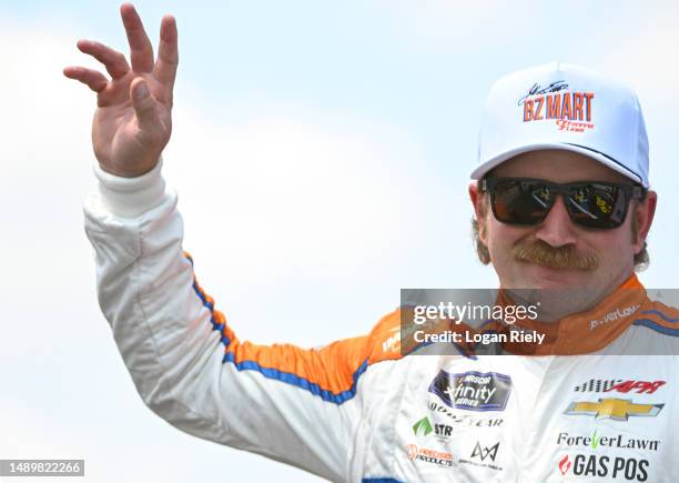 Jeffrey Earnhardt, driver of the BZ Mart/ForeverLawn Chevrolet, waves to fans as he walks onstage during driver intros prior to the NASCAR Xfinity...