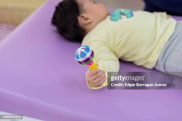 hand of a baby holding a rattle - baby rattle stock pictures, royalty-free photos & images