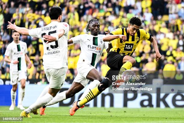 Ramy Bensebaini and Manu Kone of Borussia Mönchengladbach challenges Jude Bellingham of Borussia Dortmund during the Bundesliga match between...