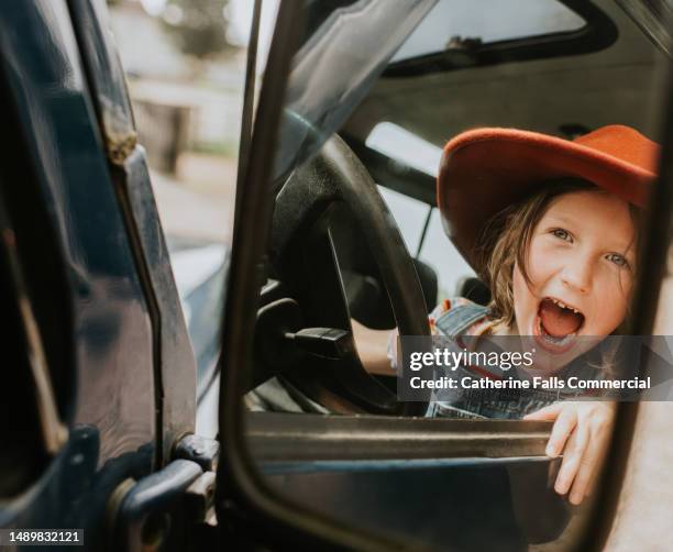 a cute little girl looks into a cars wing mirror - side view mirror stock pictures, royalty-free photos & images