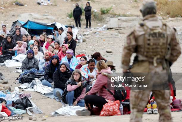 Immigrants seeking asylum in the U.S., who are stuck in a makeshift camp between border walls between the U.S. And Mexico, sit as a Customs and...