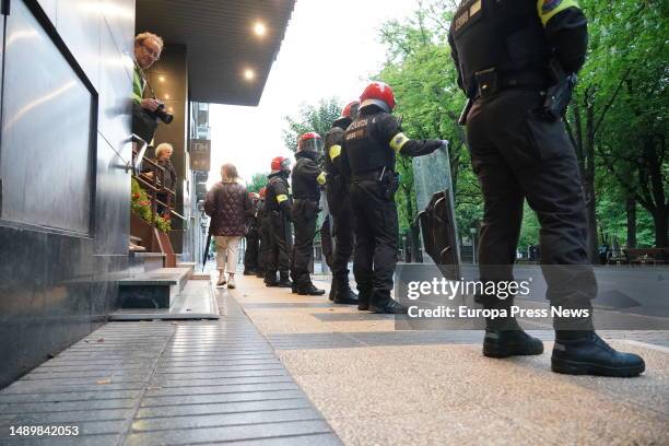 Ertzaintza police officers watch as dozens of people protest against a Vox election rally at the Hotel NH Canciller Ayala, on 13 May, 2023 in...