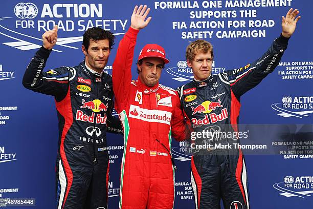 Pole sitter Fernando Alonso of Spain and Ferrari celebrates with second placed Sebastian Vettel of Germany and Red Bull Racing and third placed Mark...