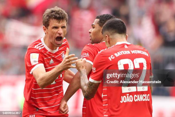 Thomas Mueller of FC Bayern Munich celebrates with teammate Joao Cancelo after scoring the team's first goal during the Bundesliga match between FC...