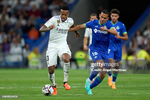 Eder Militao of Real Madrid is challenged by Angel Algobia of Getafe CF during the LaLiga Santander match between Real Madrid CF and Getafe CF at...