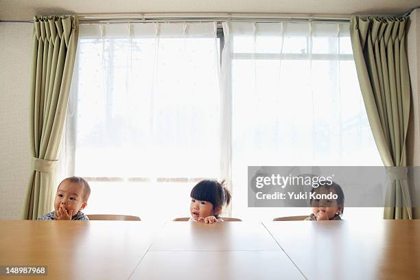 Three children sitting on the chair.