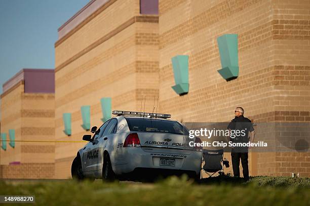 Aurora Police officers continue to maintain a secure perimeter around the Century 16 movie theater a day after a gunman killed 12 people and injured...