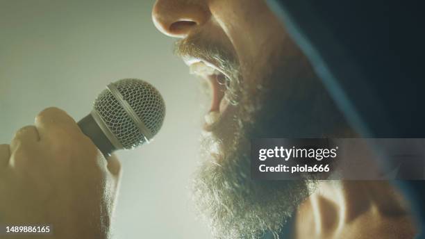 rocksänger schreit in einer live-show mit bühnenlichtern - microphone mouth stock-fotos und bilder