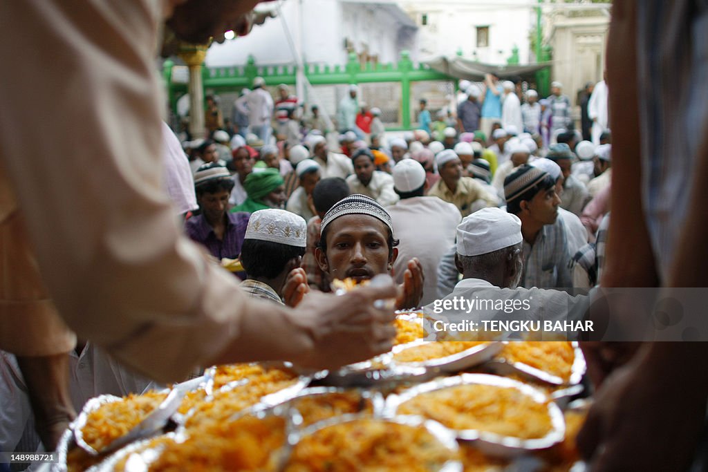 A Muslim man receives a plate of biryani