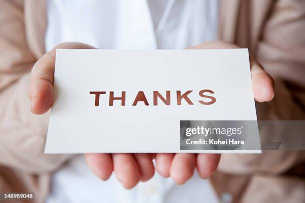 a woman holding a card - dankbarkeit stock-fotos und bilder