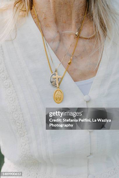 christian necklaces  on white shirt - gelovige stockfoto's en -beelden