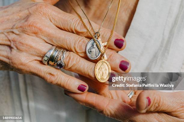 senior lady showing catholic necklaces - gebetskette stock-fotos und bilder