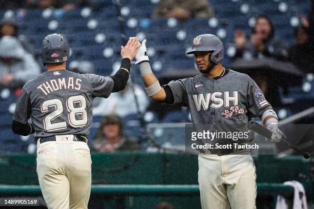 Lane Thomas of the Washington Nationals celebrates with Keibert Ruiz after scoring a run against the New York Mets during the first inning at...