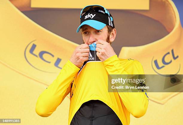 Bradley Wiggins of Great Britain and SKY Procycling kisses the maillot jaune as he celebrates on the podium after securing the yellow jersey of the...