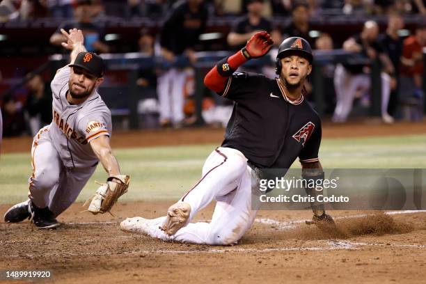 Ketel Marte of the Arizona Diamondbacks scores on a wild pitch by pitcher Tristan Beck of the San Francisco Giants during the eighth inning at Chase...