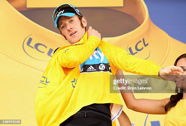 Bradley Wiggins of Great Britain and SKY Procycling celebrates on the podium after securing the yellow jersey of the general classification during...
