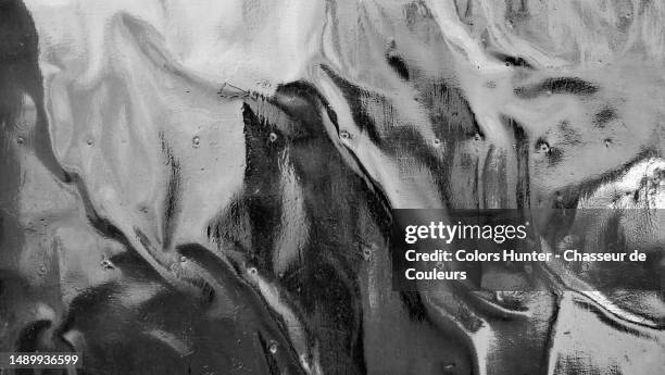 black and white photograph of a deformed and dented metal plate in lisbon, portugal - dented stock pictures, royalty-free photos & images