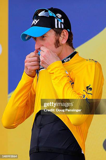 Bradley Wiggins of Great Britain riding for Sky Procycling kisses the race leader's yellow jersey after defending it with a win in the individual...