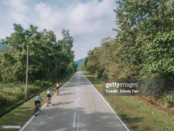 drone view road trip at rural area 3 asian chinese female cyclist cycling in the morning - groep fietsers stockfoto's en -beelden