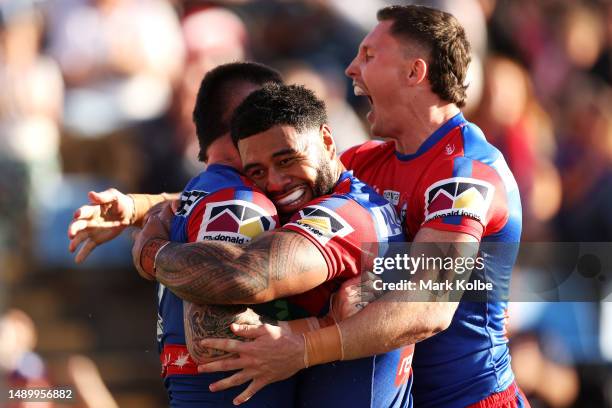 Bradman Best of the Knights celebrates with his team mates Greg Marzhew and Tyson Gamble after scoring a try during the round 11 NRL match between...