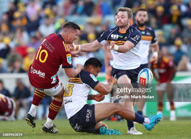 Freddie Burns of the Highlanders and Len Ikitau of the Brumbies clash during the round 12 Super Rugby Pacific match between ACT Brumbies and...