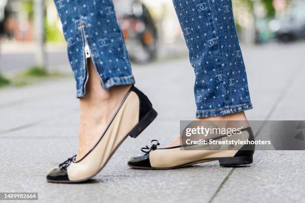 Model Annika Gassner, wearing a blue Jeans with Logo Print and ankle zipper by Chanel, and black-beige sandals by Gabriele, during a streetstyle...