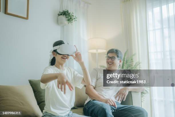 asian father and daughter playing a game using vr headsets. - 3d daughter stock pictures, royalty-free photos & images