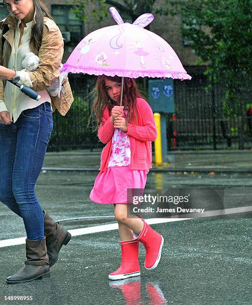 Katie Holmes and Suri Cruise seen walking in the rain in Chelsea on July 20, 2012 in New York City.