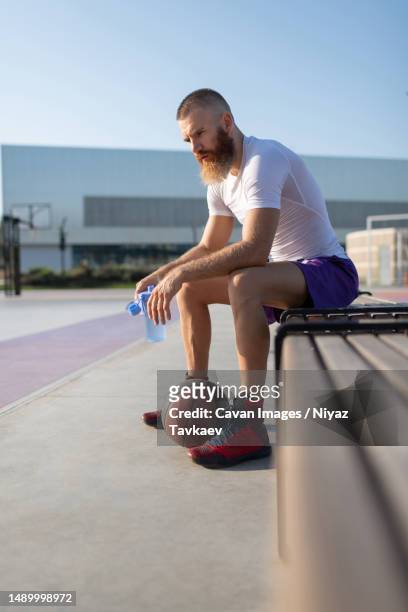 sportsman resting on basketball court - street basketball imagens e fotografias de stock