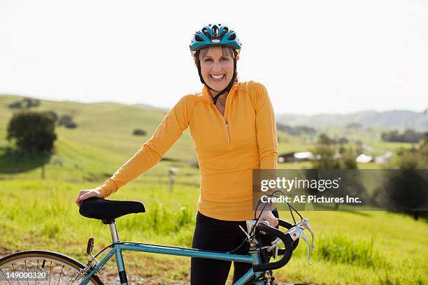 woman standing with bike - cycling helmet stock pictures, royalty-free photos & images