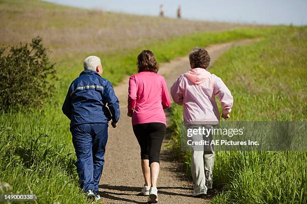 three senior citizens walking - 3 old men jogging stock-fotos und bilder