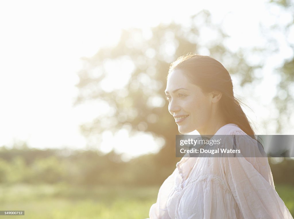 Profile of woman in hazy meadow.