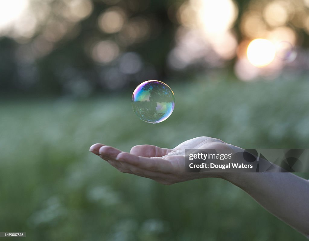 Female hand and floating bubble.