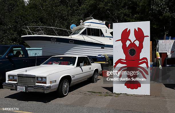 Car and a boat are parked next to a painting of a lobster at Benny's Famous Fried Clams on July 21, 2012 in Portland, Maine. A mild winter and warmer...