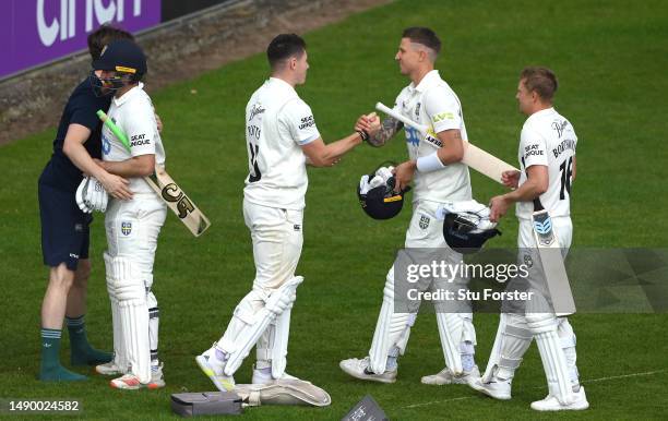 Durham batsmen Ben Raine and Brydon Carse who is congratulated by Matthew Potts as his runner and captain Scott Borthwick looks on after Durham had...