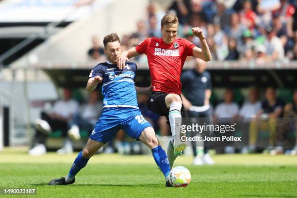 Fabian Kunze of Hannover 96 is challenged by Matthias Bader of SV Darmstadt 98 during the Second Bundesliga match between Hannover 96 and SV...