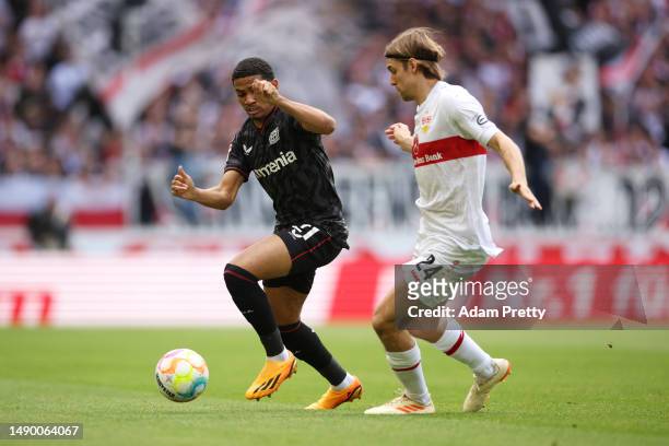 Amine Adli of Bayer 04 Leverkusen runs with the ball whilst under pressure from Borna Sosa of VfB Stuttgart during the Bundesliga match between VfB...