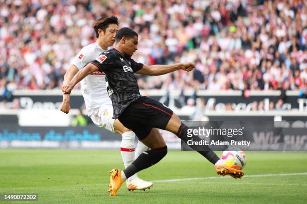 Amine Adli of Bayer 04 Leverkusen passes the ball whilst under pressure from Hiroki Ito of VfB Stuttgart during the Bundesliga match between VfB...