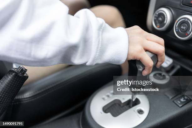hand female driver using automatic gear shift system in car. woman shifting an automatic car. - shift gear knob stock pictures, royalty-free photos & images
