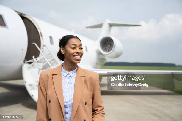 cheerful young businesswoman travelling on private jet - berkshire england stock pictures, royalty-free photos & images