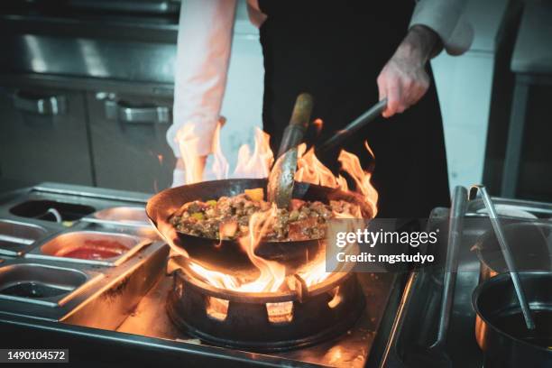 close-up of chef's hand flaming - i was turning into a vegetable stock pictures, royalty-free photos & images