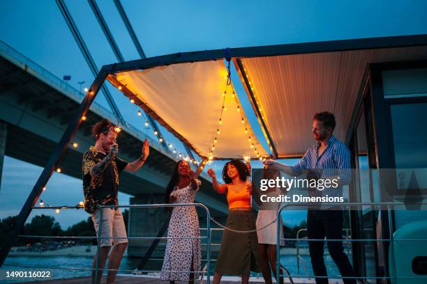 happy friends on a catamaran having a party - catamaran stock pictures, royalty-free photos & images