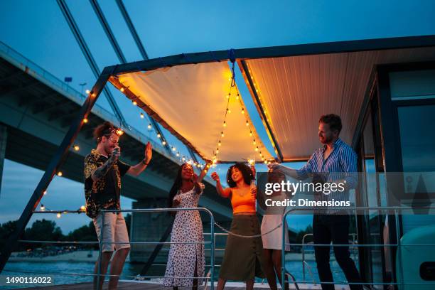 happy friends on a catamaran having a party - sailing ship night stock pictures, royalty-free photos & images