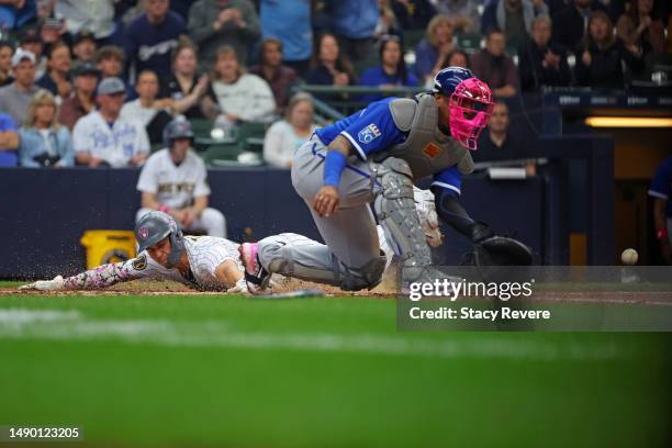Tyrone Taylor of the Milwaukee Brewers beats a tag at home by Salvador Perez of the Kansas City Royals during the third inning at American Family...