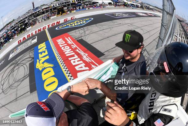 Honorary starters and former NASCAR Cup Series drivers Ricky Craven and Kurt Busch fist bump in the flagstand after the start of the NASCAR Cup...