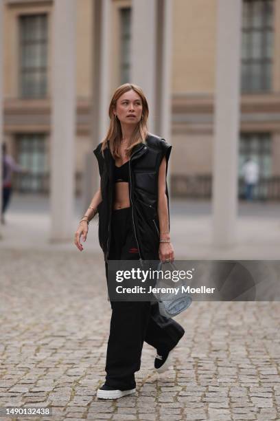 Nadine Berneis seen wearing Young poets black leather oversized vest, Prada platform black and white logo sneaker, Balenciaga nylon oversized jogging...