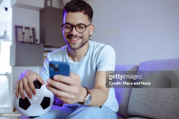 the young man is looking for the results of a soccer game online - finals game one stockfoto's en -beelden