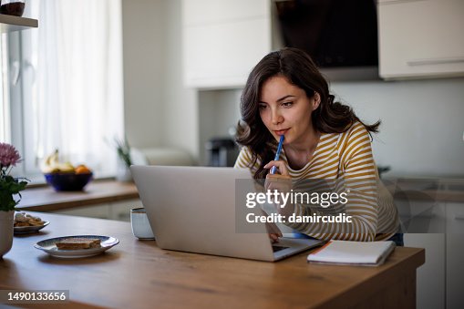 Young woman using a laptop while working from home Young woman using a laptop while working from home